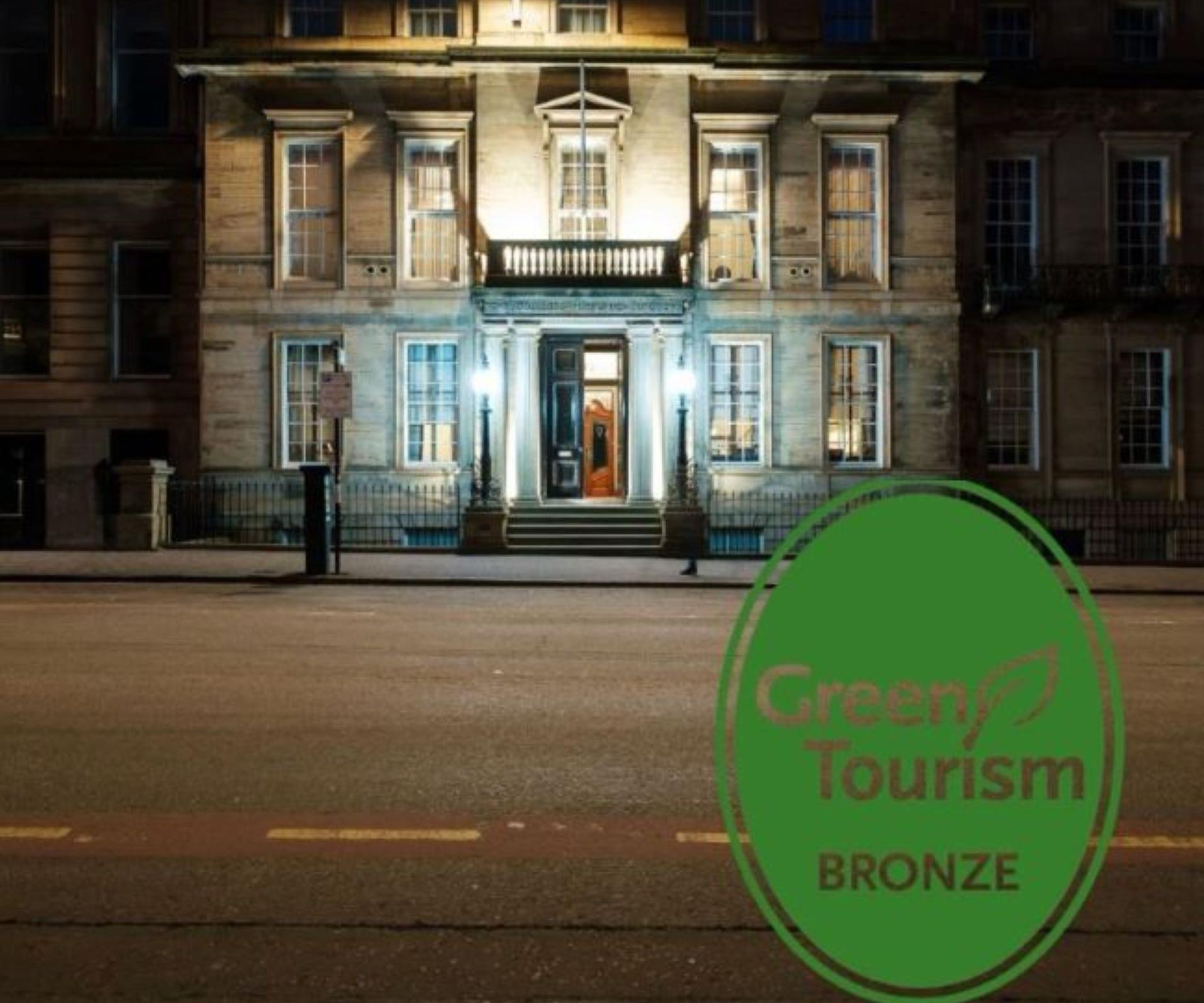 Bronze green tourism logo on an image of the college building